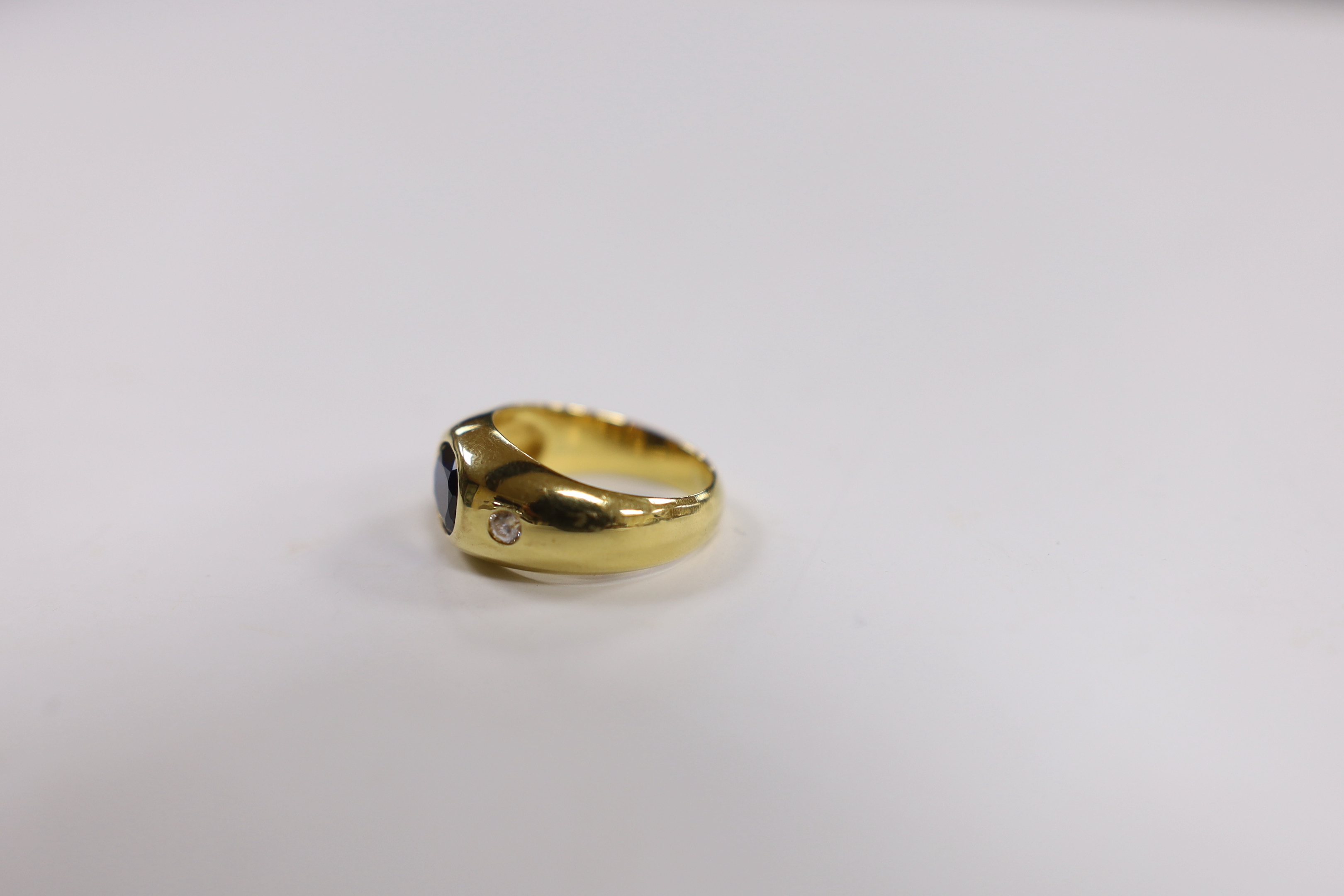 A 750 yellow metal, synthetic sapphire? and two stone simulated diamond gypsy set ring, size K, gross weight 7.8 grams.
